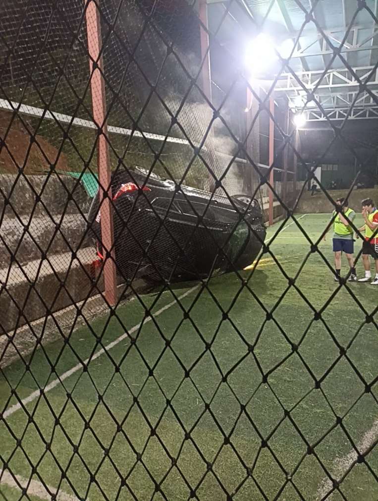 Carro cae en cancha de fútbol 5